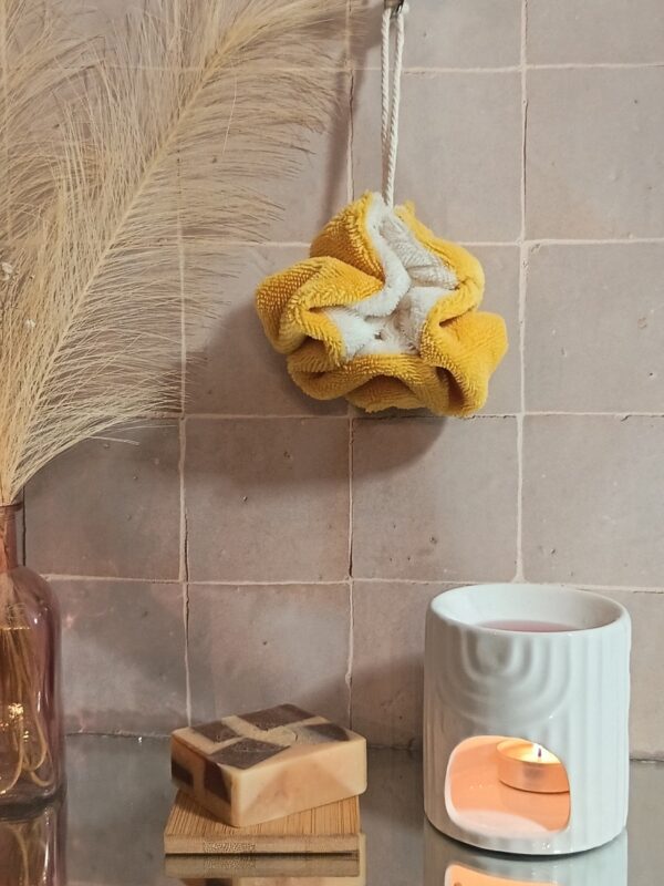 Fleur de douche bicolore jaune moutarde et crème en fibre de bambou, idéale pour une routine beauté zéro déchet.