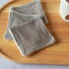 Lot de lingettes lavables exfoliantes avec une face en filet de coton gris pour un gommage doux du visage et un verso en éponge de bambou crème.