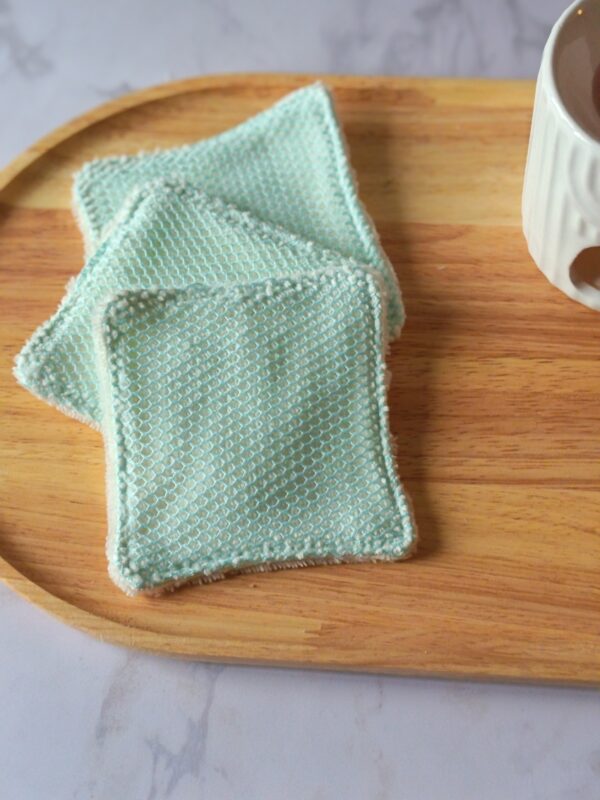 Lingettes lavables bifaces avec filet exfoliant vert d'eau et éponge de bambou ultra-douce pour nettoyer et exfolier la peau en douceur.