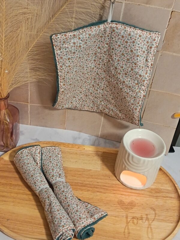 Serviette multi-usage suspendue avec un tissu fleuri printanier sur fond blanc, doublée d'une éponge en bambou coloris indigo.