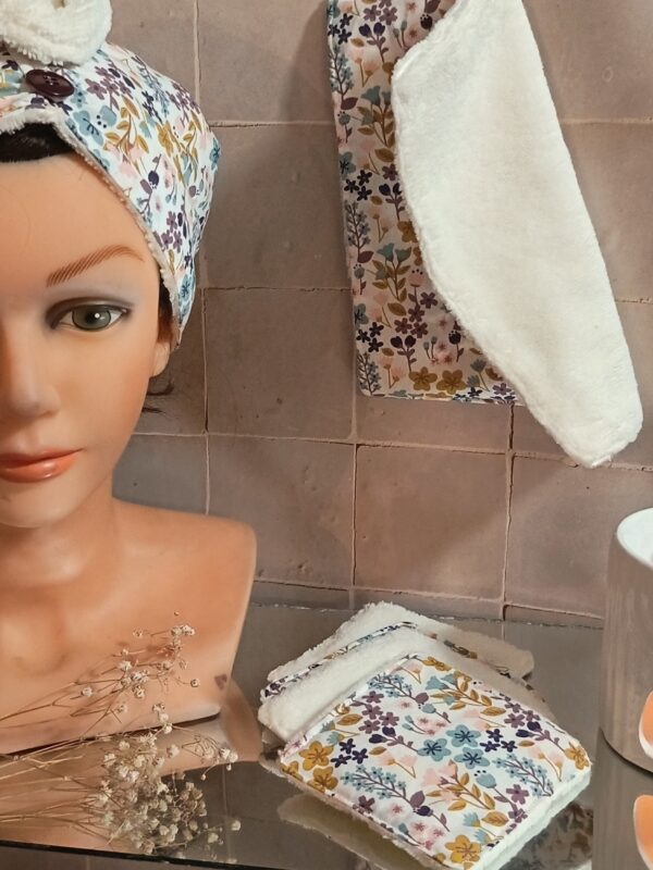 Détail du coffret soin : empilement de 4 lingettes lavables et mini serviette visage en éponge de bambou ultra-douce et coton imprimé.