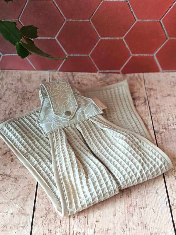 Essuie-main suspendu en coton et nid d'abeille lin, présenté plié pour laisser apparaître les finitions artisanales.