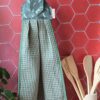Essuie-main suspendu artisanal Malili_fée composé d'un tissu nid d'abeille vert eucalyptus et d'une attache en coton à motif plumes.