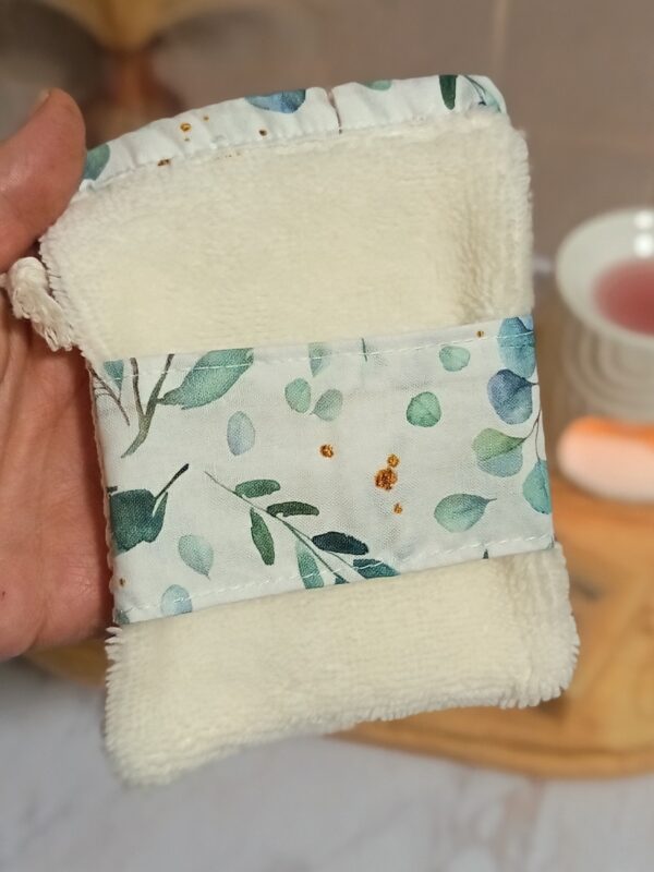 Détail de la face ultra-douce en éponge de bambou crème d'un gant sauve-savon, décoré d'une bande centrale en coton aux imprimés botaniques d'eucalyptus.