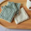Lingettes lavables écologiques avec imprimé graphique d'hexagones vert émeraude et doré, idéales pour un démaquillage zéro déchet.
