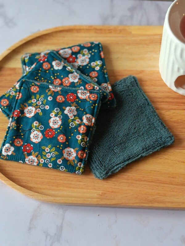 Lingettes démaquillantes lavables avec tissu japonais bleu canard à fleurs rouges et blanches, face absorbante en éponge gris foncé.