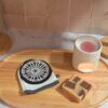 Gant de toilette individuel blanc avec un imprimé original représentant une jante de voiture grise et noire, posé à côté d'un savon artisanal.