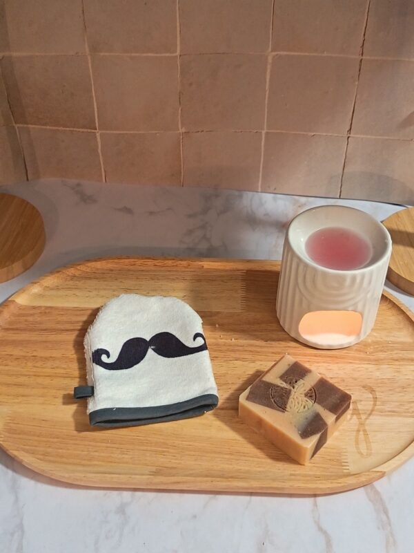 Mini-gant blanc en éponge avec une grande moustache noire stylisée au centre et une bordure grise.