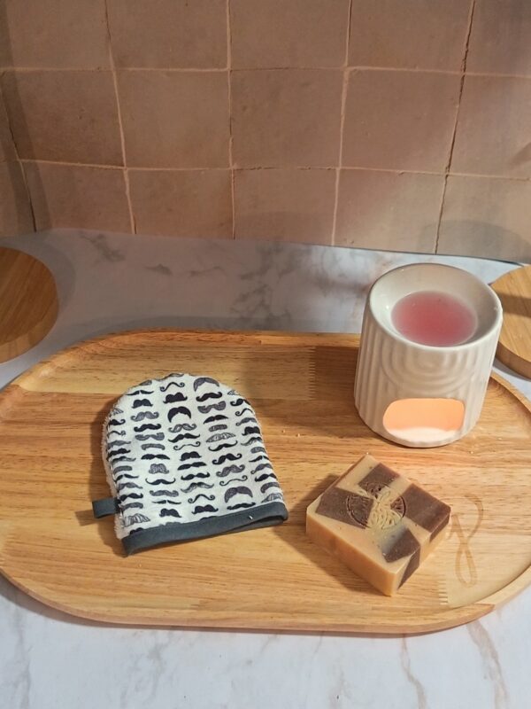 Gant de toilette lavable couvert d'un motif répétitif de petites moustaches noires de styles variés.