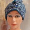 Serviette à cheveux turban avec doublure en éponge de bambou bleu pétrole et tissu extérieur à motifs de fleurs blanches sur fond bleu foncé.
