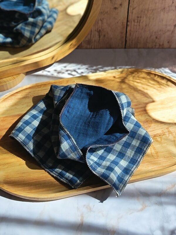 Mouchoir tissu double gaze vichy bleu et blanc Malili_fée, déplié sur un plateau en bois pour montrer sa texture gaufrée et douce.