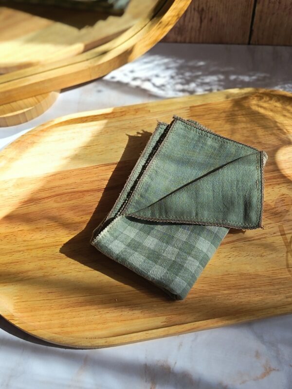Mouchoir tissu double gaze plié, motif vichy vert pastel, un accessoire zéro déchet élégant sur un plateau en bois.