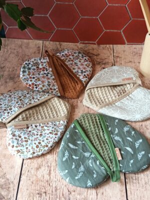 Assortiment de maniques de cuisine artisanales en forme de cœur Malili_fée : motifs plumes vert eucalyptus, fleurs Britney lin, Milly rose thé caramel et Éléoni tomette.