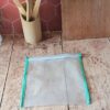 Le sac de congélation réutilisable de taille M ($21 \times 23\text{ cm}$) présenté seul à plat sur une table en bois. Le biais vert menthe apporte une touche décorative et soignée à cet accessoire écoresponsable.