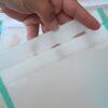 Gros plan sur la large bande agrippante blanche d'une pochette de congélation durable. La bande s'étend sur toute la largeur de l'ouverture pour assurer l'étanchéité et la bonne conservation des aliments.