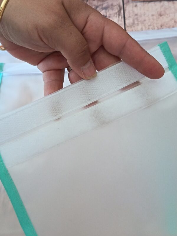 Gros plan sur la large bande agrippante blanche d'une pochette de congélation durable. La bande s'étend sur toute la largeur de l'ouverture pour assurer l'étanchéité et la bonne conservation des aliments.