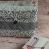Pochette à livre de poche écoresponsable matelassée à motif léopard et pois, présentée avec un roman de poche.