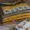 Pile de housses et pochette à livre de poche en tissu aux imprimés géométriques, floraux et graphiques jaunes et bleus.