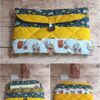 Pochette à livre de poche en tissu Modèle 1 à motifs visages artistiques, fleurs bleues et bande jaune moutarde.