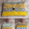 Pochette à livre de poche en tissu Modèle 5 à motifs floraux et éventails jaunes, dos illustré de visages modernes.