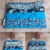 Pochette à livre de poche Modèle 5 matelassée bleu canard, ornée d'un motif de fleurs blanches et de petites baies bleues.