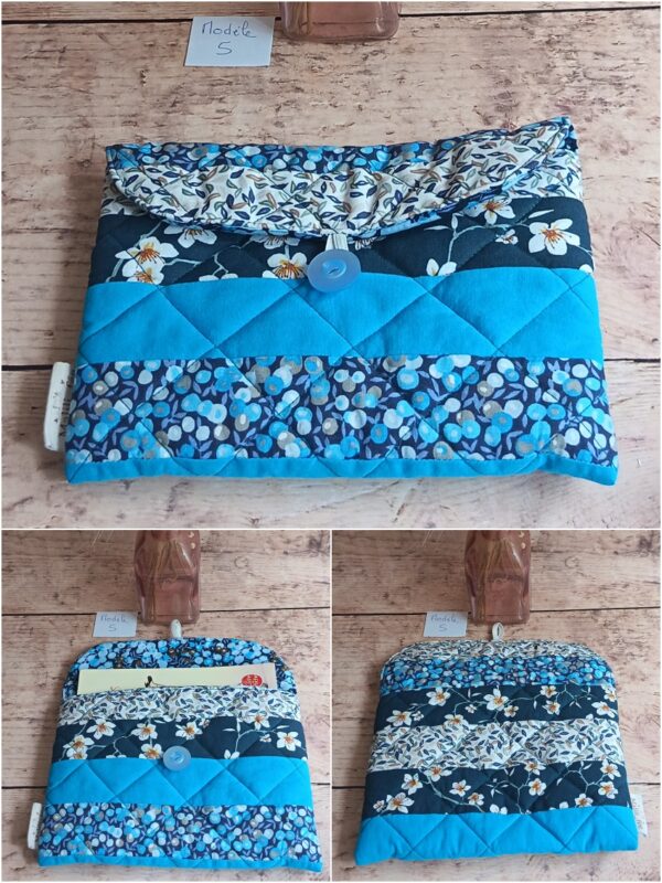 Pochette à livre de poche Modèle 5 matelassée bleu canard, ornée d'un motif de fleurs blanches et de petites baies bleues.