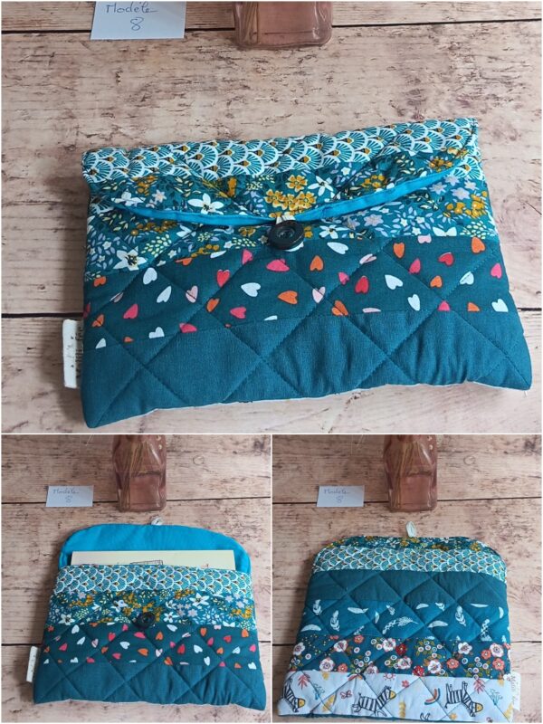 Pochette à livre de poche Modèle 8 en patchwork matelassé turquoise et bleu, avec motifs cœurs, fleurs et éventails.