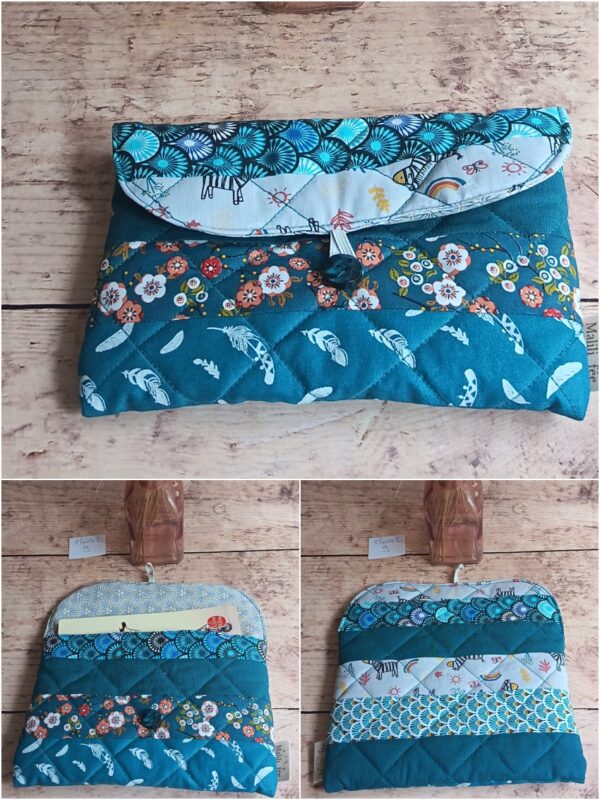 Pochette à livre de poche Modèle 9 matelassée bleu canard, avec patchwork de motifs zèbres, plumes blanches et fleurs, vue ouverte et fermée.