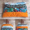 Pochette à livre de poche originale Modèle 1 en tissu orange et feuillage tropical, avec roman inséré à l'intérieur.