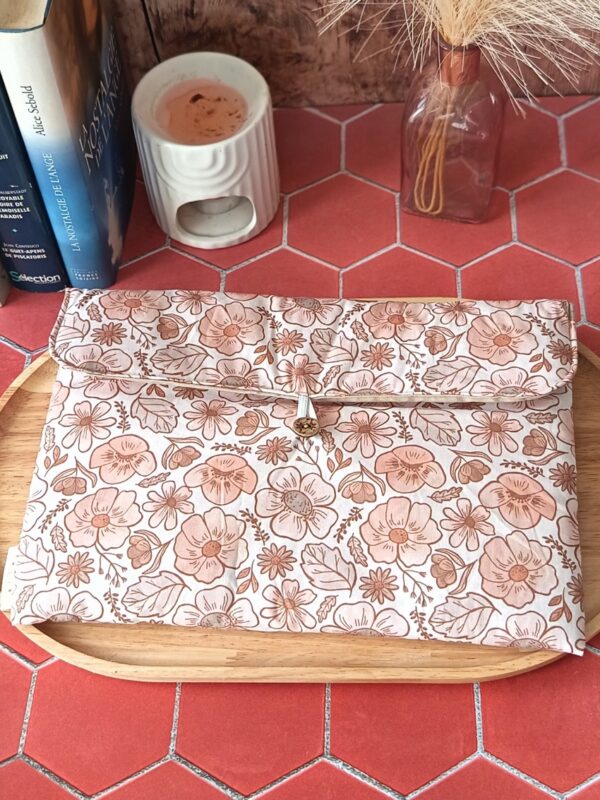 Pochette grand livre tissu matelassée motif Fleur Pastel avec bouton en bois posée sur plateau