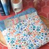 Pochette grand livre tissu Hortense Bleu entrouverte laissant apparaître un roman volumineux et sa doublure bleue