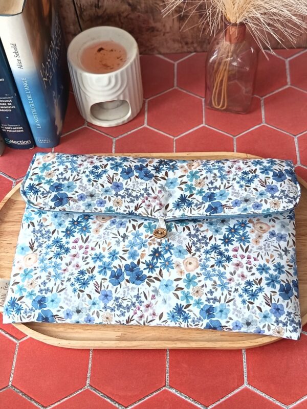 Pochette grand livre tissu matelassée motif Romane aux fleurs bleues et violettes sur plateau en bois