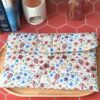 Pochette grand livre tissu motif Rozenn Prune aux fleurs colorées fermée par un bouton en bois