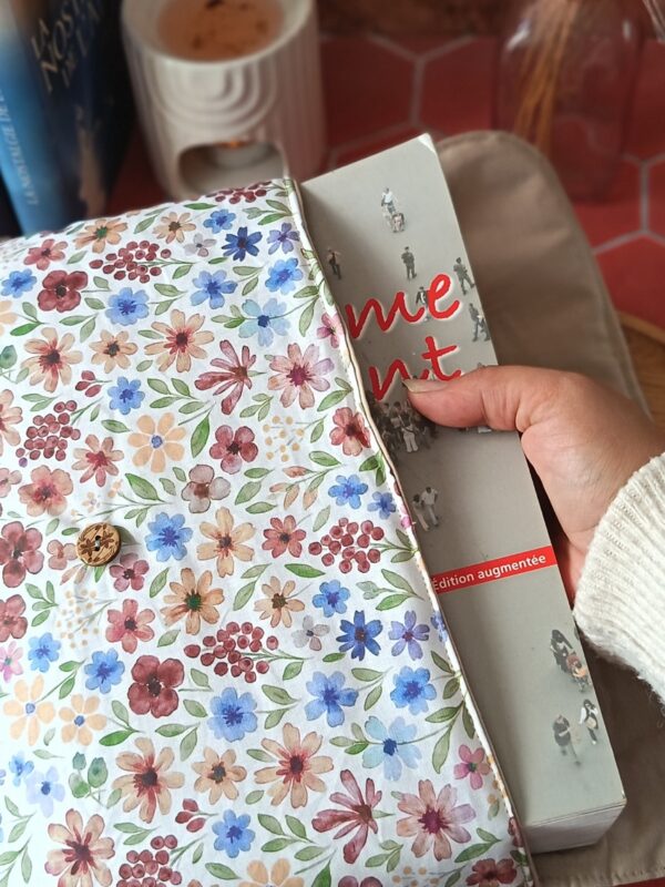 Main glissant un pavé volumineux dans la pochette grand livre tissu Rozenn Prune matelassée
