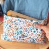 Vue détaillée de la pochette livre broche tissu Hortense Bleu ouverte montrant sa doublure bleue et un roman