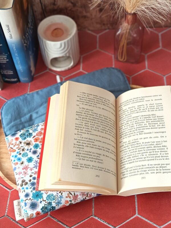 Roman broché ouvert posé sur la pochette livre broche tissu matelassée Hortense Bleu