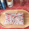Pochette livre de poche tissu matelassée motif Fleur Terracotta fermée par une bride élastique et son bouton