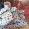 trio de pochettes à livre matelassées en tissu motif Rozenn Prune présentées sur un plateau en bois