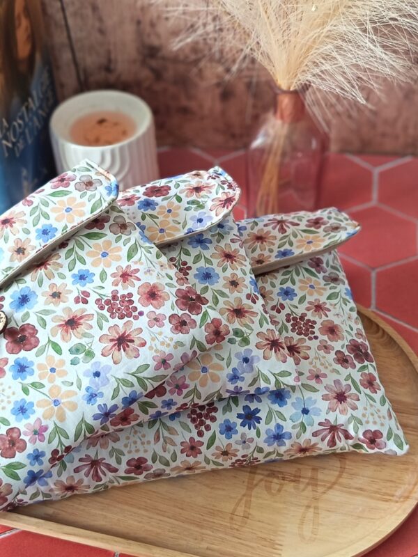 trio de pochettes à livre matelassées en tissu motif Rozenn Prune présentées sur un plateau en bois