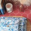 Trio de pochettes à livre matelassées en tissu motif Romane aux fleurs bleues superposées sur plateau