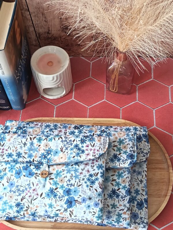 Trio de pochettes à livre matelassées en tissu motif Romane aux fleurs bleues superposées sur plateau